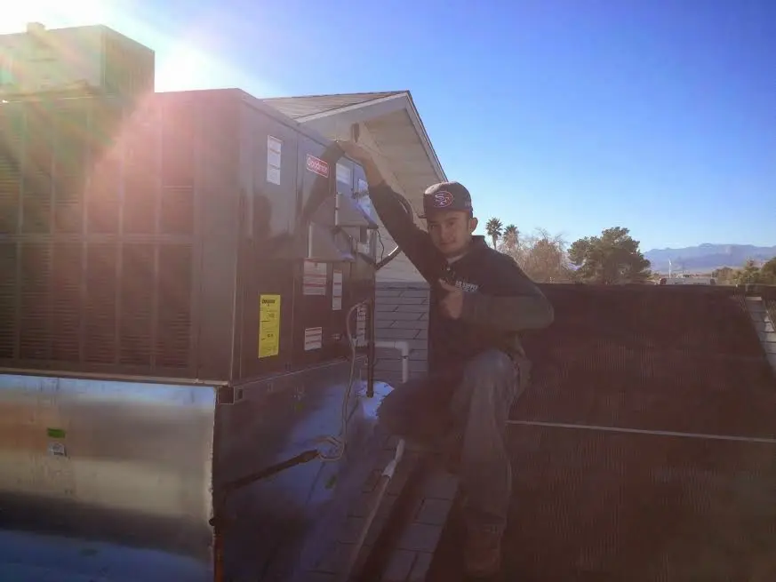 HVAC technician performing Heat Pump Repair on a rooftop unit in Vincennes